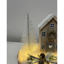 Weihnachtsdeko auf einer Baumscheibe mit einem Häuschen