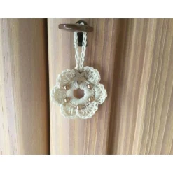 Weihnachts-Häkelkränzchen in beige mit braunen Perlen und Holzsternchen verziert