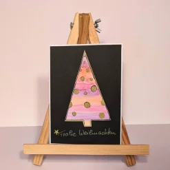 Weihnachtskarte mit handgezeichnetem rosa Weihnachtsbaum mit goldenen Sternen, Aquarell schwarz