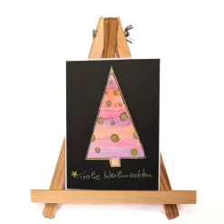 Weihnachtskarte mit handgezeichnetem rosa Weihnachtsbaum mit goldenen Sternen, Aquarell schwarz
